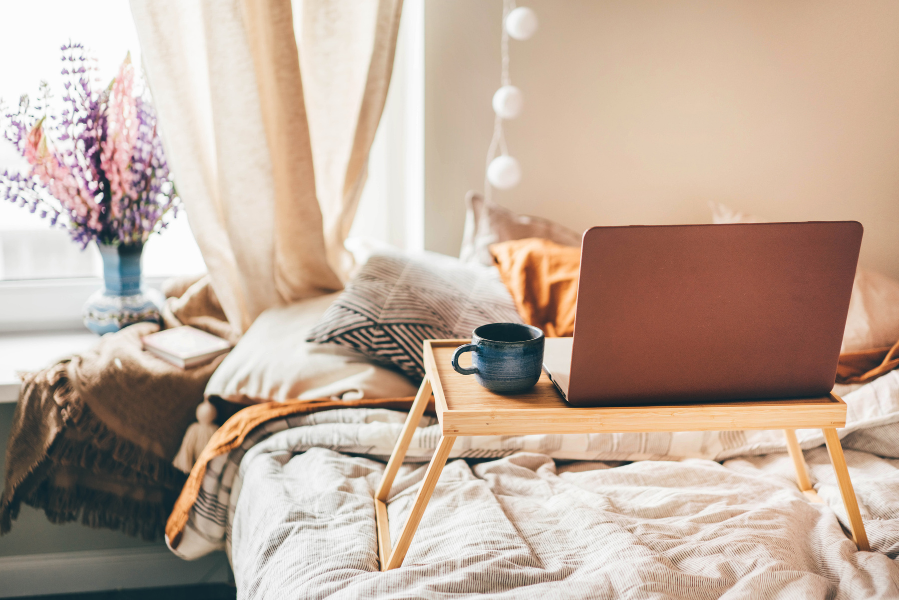 coffee and laptop on bed.